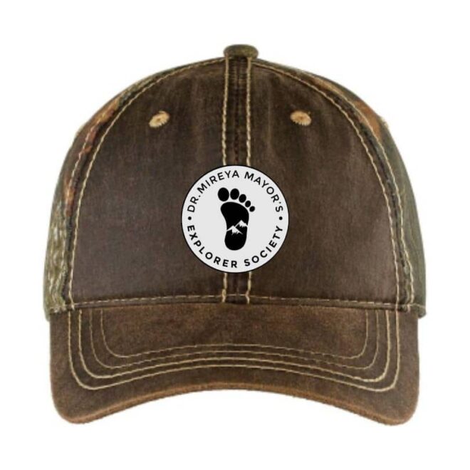 Camo snapback baseball cap with Dr. Mireya Mayor's Explorer Society logo on the front, perfect for outdoor adventures and casual wear.