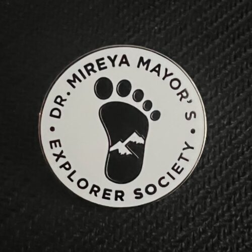 1.5-inch circular Explorer Society member pin with black text and Bigfoot footprint logo on a white background